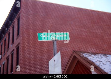 Green Church of Nazarene Way Schild hängt an einem grauen Pol mit roten Ziegelwänden auf der Rückseite in Paulus Hook in Jersey City Stockfoto