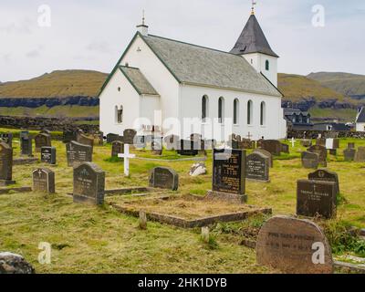 Eiði, Ejde, (Hafer), Färöer-Inseln - Sep, 2020: Kleine Kirche (Eiðis kirkja) und Friedhof im Dorf auf der Insel Eysturoy, Dänemark Stockfoto