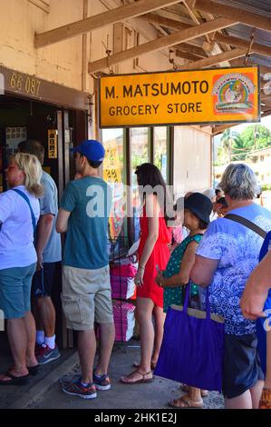 Leute bilden eine lange Schlange, draußen vor der Tür, um im Mat-Sumoto General Store auf Hawaii Eis zu rasieren Stockfoto