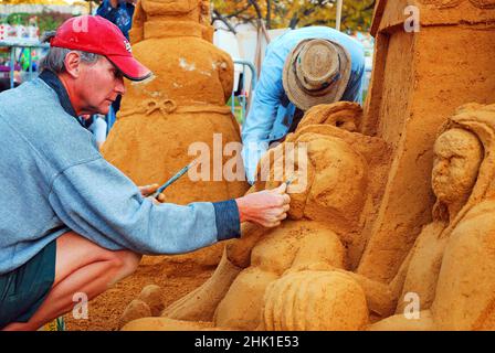 Ein Sandbildhauer achtet mit seiner Kreation auf das Detail Stockfoto