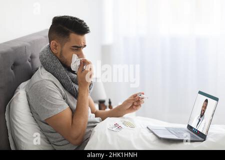 Online-Medizin. Krank Naher Osten Mann Mit Video Anruf Mit Arzt Stockfoto