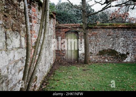 Traditionelles englisches, von Mauern umgemauertes Geheimtor im Garten Stockfoto
