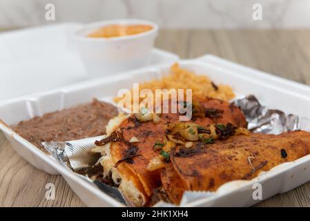 Bestellen Sie Birria Tacos, die in der Styropor-Box perfekt mit Reis und Bohnen frittiert sind. Stockfoto