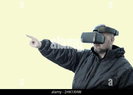 Ein Mann mit einer VR-Brille zeigt seinen Finger nach vorne. Stockfoto