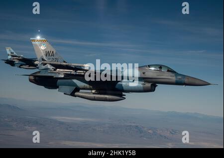 Zwei F-16C Kampffalken, die 64th Aggressor Squadron zugewiesen wurden, fliegen während einer Mission der Roten Flagge Nellis 22-1 am 28. Januar 2022 über den Nevada Test- und Trainingsbereich zurück in das Trainingsgebiet. Die 64th AGRS spielten als die Rote Kraft gegen die Blauen Kräfte in einem Training, das ‘First Timers’ Kampfmissionen priorisiert. (USA Air Force Foto von Tech. Sgt. Alexandre Montes) Stockfoto