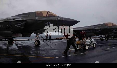 PHILIPPINISCHES MEER (Jan 29, 2022) Marineinfanteristen, die der Marine Expeditionary Unit (MEU) von 31st zugewiesen wurden, entladen die Kampfjets F-35B Lightning II aus der 31st MEU auf dem Flugdeck des nach vorne eingesetzten amphibischen Sturmschiffs USS America (LHA 6). Amerika, Flaggschiff der America Amphibious Ready Group, arbeitet zusammen mit der 31st MEU im Verantwortungsbereich der US-Flotte für 7th, um die Interoperabilität mit Verbündeten und Partnern zu verbessern und als einsatzbereite Einsatztruppe für Frieden und Stabilität in der Indo-Pazifik-Region zu dienen. (USA Navy Foto von Mass Communication Specialist 3rd CLA Stockfoto