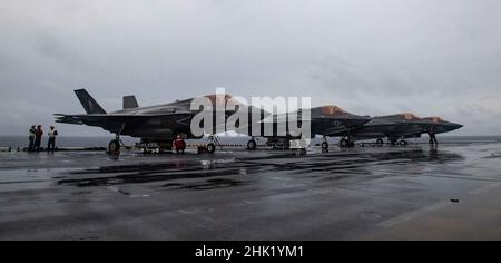 PHILIPPINISCHES MEER (Jan 29, 2022) Marineinfanteristen, die der Marine Expeditionary Unit (MEU) von 31st zugewiesen wurden, entladen die Kampfjets F-35B Lightning II aus der 31st MEU auf dem Flugdeck des nach vorne eingesetzten amphibischen Sturmschiffs USS America (LHA 6). Amerika, Flaggschiff der America Amphibious Ready Group, arbeitet zusammen mit der 31st MEU im Verantwortungsbereich der US-Flotte für 7th, um die Interoperabilität mit Verbündeten und Partnern zu verbessern und als einsatzbereite Einsatztruppe für Frieden und Stabilität in der Indo-Pazifik-Region zu dienen. (USA Navy Foto von Mass Communication Specialist 3rd CLA Stockfoto