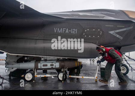 PHILIPPINISCHES MEER (Jan 29, 2022) Cpl. Antonio Sanchez, aus Douglasville, Georgia, der Marine Expeditionary Unit (MEU) von 31st zugewiesen, entlädt auf dem Flugdeck des nach vorne eingesetzten amphibischen Angriffsschiffs USS America (LHA 6) die Kampftanz eines F-35B Lightning II-Kampfflugzeugs der MEU von 31st. Amerika, Flaggschiff der America Amphibious Ready Group, arbeitet zusammen mit der 31st MEU im Verantwortungsbereich der US-Flotte für 7th, um die Interoperabilität mit Verbündeten und Partnern zu verbessern und als einsatzbereite Einsatztruppe für Frieden und Stabilität in der Indo-Pazifik-Region zu dienen. (USA Navy Pho Stockfoto