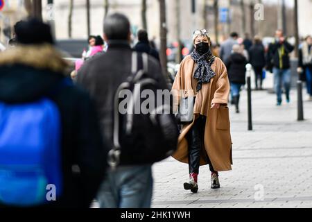 Paris, Frankreich, 1. Februar 2022. Die Abbildung zeigt, wie Menschen in der Straße (Avenue des Champs-Elysées) in der Nähe des Triumphbogens in Paris, Frankreich, am 1. Februar 2022 Gesichtsmasken als Schutz gegen Covid-19 tragen. Das Pariser Polizeipräsidium kündigte am 31. Januar das Ende der Maskenpflicht im Freien in der Hauptstadt vom 2. Februar an. Insbesondere aufgrund des Rückgangs in den Fällen von Covid-19. Stockfoto