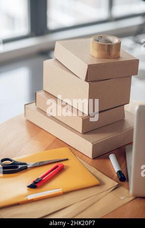 Pakete auf einem runden Schreibtisch aus Holz gestapelt Stockfoto