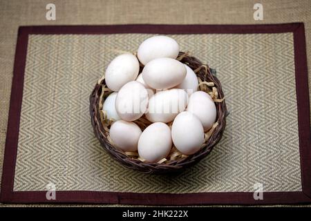 Rohe Bio-Whhite-Eier im Weidenkorb Stockfoto