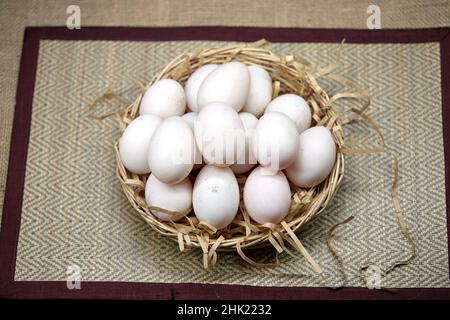 Rohe Bio-Whhite-Eier im Weidenkorb Stockfoto