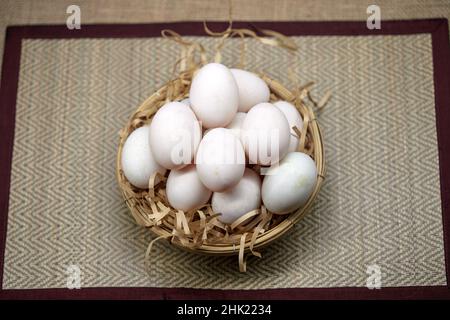 Rohe Bio-Whhite-Eier im Weidenkorb Stockfoto