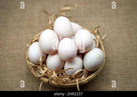 Rohe Bio-Whhite-Eier im Weidenkorb Stockfoto