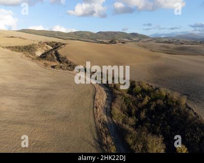 Luftpanorama auf den Hügeln des Val d'Orcia in der Nähe von Pienza, Toskana, Italien. Toskanische Landschaft mit Zypressen, Weinbergen, Wäldern und gepflügten Feldern Stockfoto