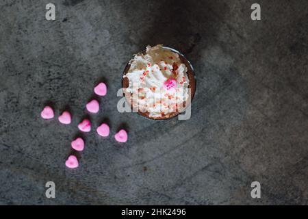 Draufsicht auf XO valentine, die Schokolade mit Schlagsahne und Süßigkeiten trinkt Stockfoto
