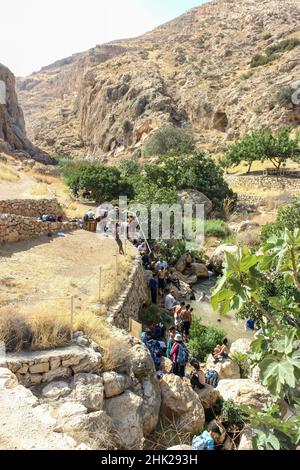 Die Menschen versammeln sich an einer Quelle im Naturschutzgebiet ein Prat entlang des Baches im Wadi Qelt bei Almon, AKA: Anatot, im Westjordanland. Stockfoto