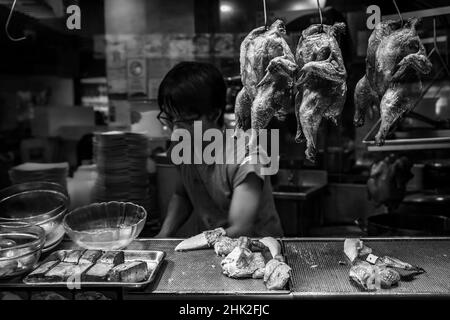 Singapur - 07. September 2019: Straßenhändler Verkäufer von chinesischen Stand in Lau Pa Sat, Telok Ayer Market Hawker Center Kochen Lebensmittel, schwarz und weiß Stockfoto