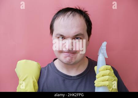 Glücklicher Hausmeister, der mit gelben Handschuhen eine Geste mit Ja zeigt, Porträt auf rosafarbenem Hintergrund Stockfoto