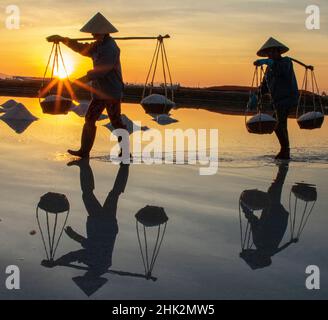 Vietnam. DOC Lassen Sie Salzsee. Arbeiter ernten das Salz. Sonnenaufgang am frühen Morgen. Stockfoto