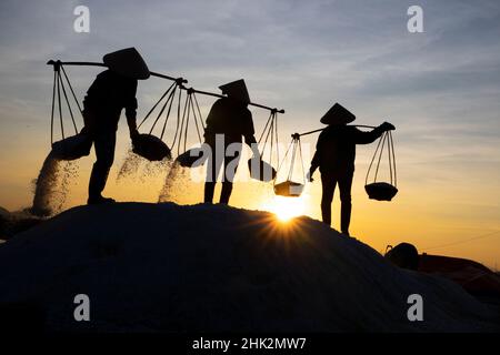 Vietnam. DOC Lassen Sie Salzsee. Arbeiter ernten das Salz. Sonnenaufgang am frühen Morgen. Stockfoto