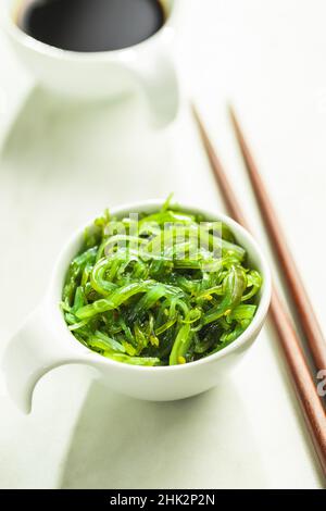 Grüner Wakame. Algensalat und Sojasauce in einer Schüssel. Stockfoto