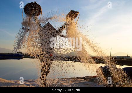 Vietnam. DOC Lassen Sie Salzsee. Arbeiter ernten das Salz. Sonnenaufgang am frühen Morgen. Stockfoto