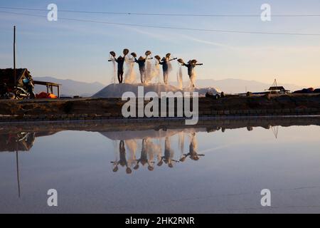 Vietnam. DOC Lassen Sie Salzsee. Arbeiter ernten das Salz. Sonnenaufgang am frühen Morgen. Stockfoto