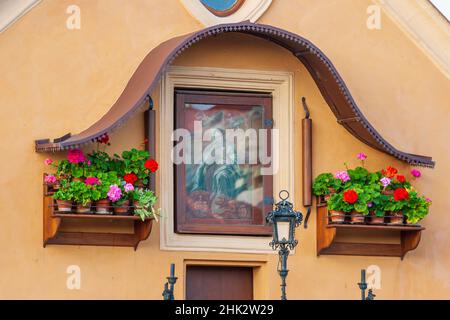 Kleiner bemalter Schrein auf dem Gebäude neben der Karlsbrücke in Prag, UNESCO-Weltkulturerbe, Tschechische Republik. Stockfoto