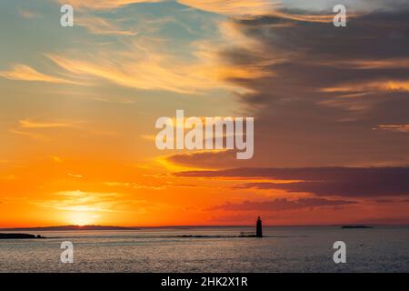 Spektakuläre Sonnenaufgangswolken über dem RAM Island Ledge Lighthouse in Portland, Maine, USA Stockfoto