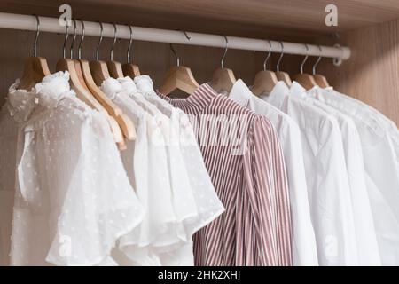 Kleidung im Schrank. Leichte Vintage-Damenbekleidung auf Kleiderbügeln im Schrank der Ankleidekabine. Modetrends, Textilien, Recycling, aus zweiter Hand. Hochwertige Fotos Stockfoto