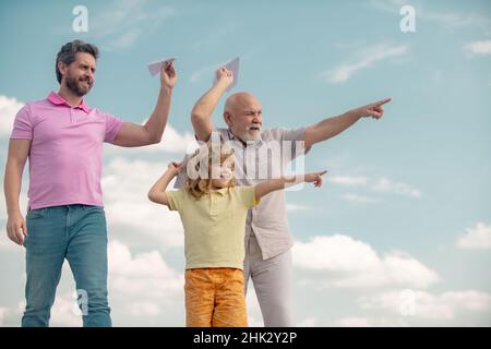 Drei verschiedene Generationen alt Großvater Vater und Kind Sohn spielen mit Spielzeug Flugzeug im Freien. Journey Reise Reisekonzept. Stockfoto