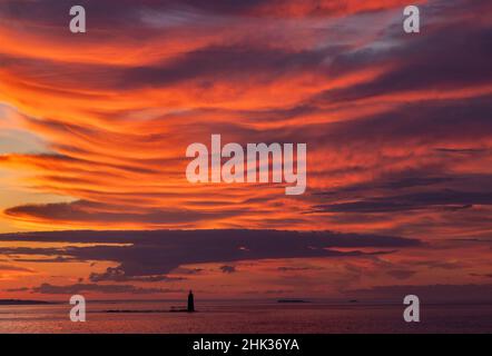 Spektakuläre Sonnenaufgangswolken über dem RAM Island Ledge Lighthouse in Portland, Maine, USA Stockfoto