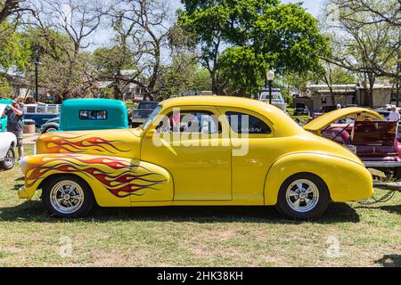 Marble Falls, Texas, USA. Gelbe Vintage Hot Rod mit Flammen auf der Haube gemalt. (Nur Für Redaktionelle Zwecke) Stockfoto