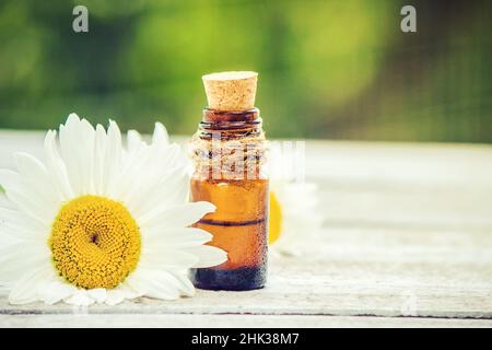 Ätherisches Kamillenöl in einer kleinen Flasche. Selektiver Fokus. Stockfoto