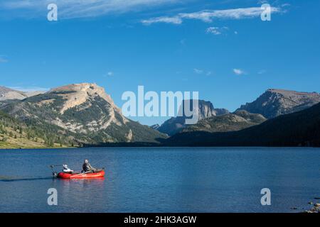 USA, Wyoming. Männer entspannen sich auf einem Fischerboot, Blick auf White Rock Mountain und Squaretop Peak über dem Green River Lake Stockfoto