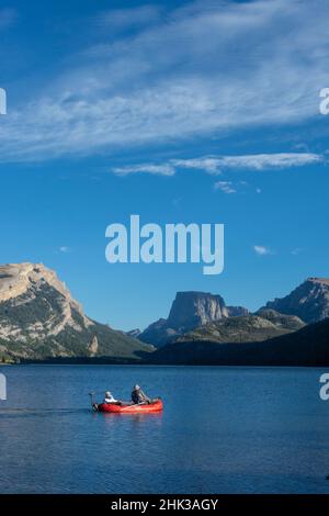 USA, Wyoming. Männer entspannen sich auf einem Fischerboot, Blick auf White Rock Mountain und Squaretop Peak über dem Green River Lake Stockfoto