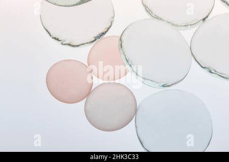 Klarglas und beigefarbene Kieselsteine aus Glas mit Licht Stockfoto