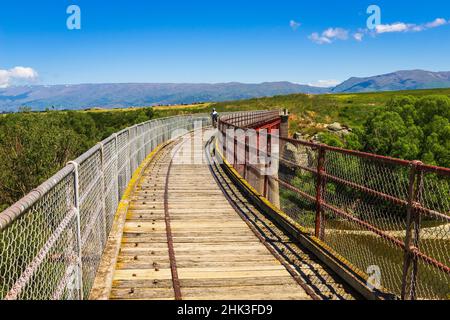 Radfahrer überqueren die Manuherikia River Brücke auf dem Otago Central Rail Trail, Otago, South Island, Neuseeland Stockfoto