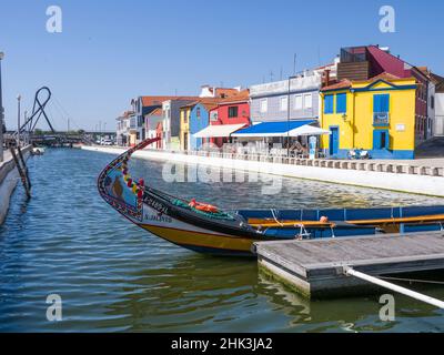 Portugal, Aveiro. Moliceiro Boot im Kanal entlang der Straße der bunten Gebäude. Stockfoto