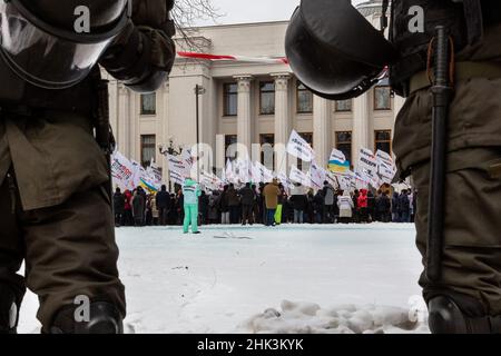 Kiew, Ukraine. 01st. Februar 2022. Die Bereitschaftspolizei sieht zu, wie Demonstranten mit Fahnen und Transparenten vor Regierungsgebäuden demonstrieren, während sie gegen die fehlenden Geschäftsmöglichkeiten durch die Coronavirus-Sperre protestieren.Mitglieder von Save FOP (Individual Entrepreneurs) Die Organisation demonstrierte im Zentrum von Kiew in einem Anti-Lockdown-marsch trotz steigender Spannungen mit Russland, als Russland mehr than100 Soldaten an der ukrainischen Grenze massierte und der Westen befürchtet, in die Ukraine eingedrungen zu sein. Kredit: SOPA Images Limited/Alamy Live Nachrichten Stockfoto