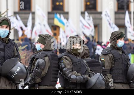 Kiew, Ukraine. 01st. Februar 2022. Die Bereitschaftspolizei schaut zu, wie Demonstranten vor Regierungsgebäuden demonstrieren, während sie gegen die fehlenden Geschäftsmöglichkeiten durch die Coronavirus-Sperre protestieren.Mitglieder von Save FOP (Individual Entrepreneurs) Die Organisation demonstrierte im Zentrum von Kiew in einem Anti-Lockdown-marsch trotz steigender Spannungen mit Russland, als Russland mehr than100 Soldaten an der ukrainischen Grenze massierte und der Westen befürchtet, in die Ukraine eingedrungen zu sein. Kredit: SOPA Images Limited/Alamy Live Nachrichten Stockfoto