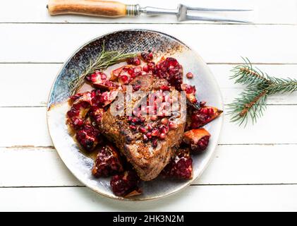 Köstliches Stück Fleisch gebraten mit Granatapfel. Stockfoto