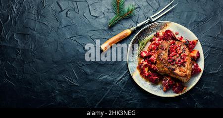 Köstliches Stück Fleisch gebraten mit Granatapfel. Platz für Text. Ort des Rezepts Stockfoto