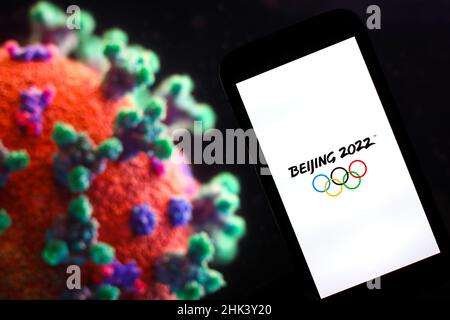 Auf dieser Fototafel ist ein Logo für die Olympischen Winterspiele 2022 in Peking abgebildet, das vor einem Bild eines Coronavirus zu sehen ist. Stockfoto