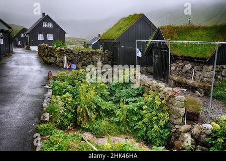 Typisches kleines Dorf auf den Färöern. Tradicional faroese grasbedeckten Häusern im Dorf Bour. Vagar, Färöer. Stockfoto