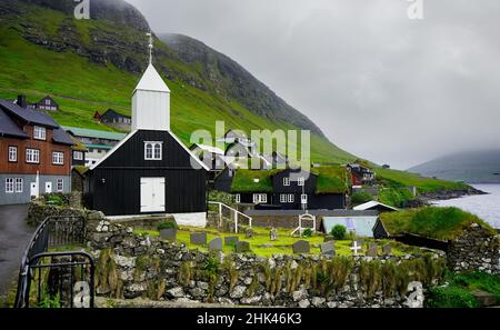 Typisches kleines Dorf auf den Färöern. Tradicional faroese grasbedeckten Häusern im Dorf Bour. Vagar, Färöer. Stockfoto