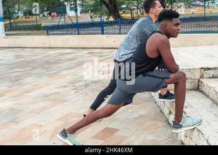 Zwei Freunde in Sportswear, die sich auf der Straße strecken Stockfoto