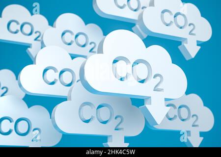 CO2 Reduktionskonzept. Wolkenförmige Objekte mit dem ausgestanzten Wort CO2 und einem Pfeil nach unten vor einem blauen Hintergrund. Stockfoto