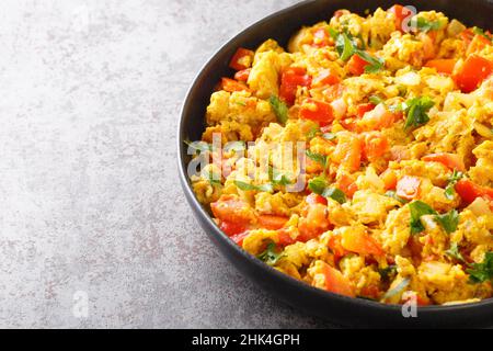 Ei Bhurji gewürzte indische Rühreier in der Nähe auf dem Teller auf dem Tisch. Horizontal Stockfoto